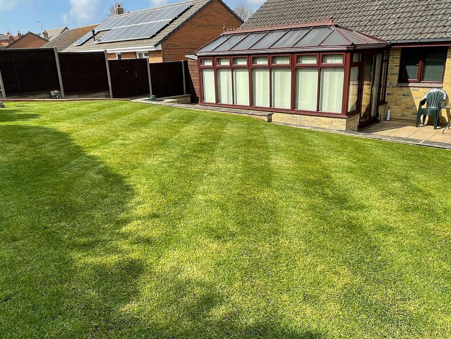 Freshly mown lawn with neat stripes beside a house