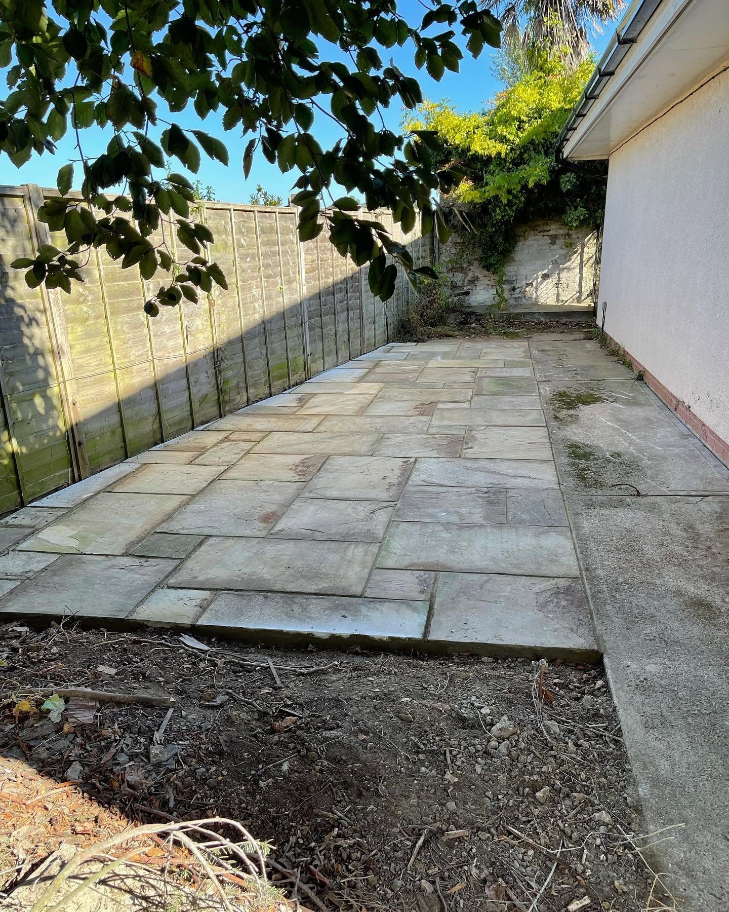 New patio paving and brick edging beside a house