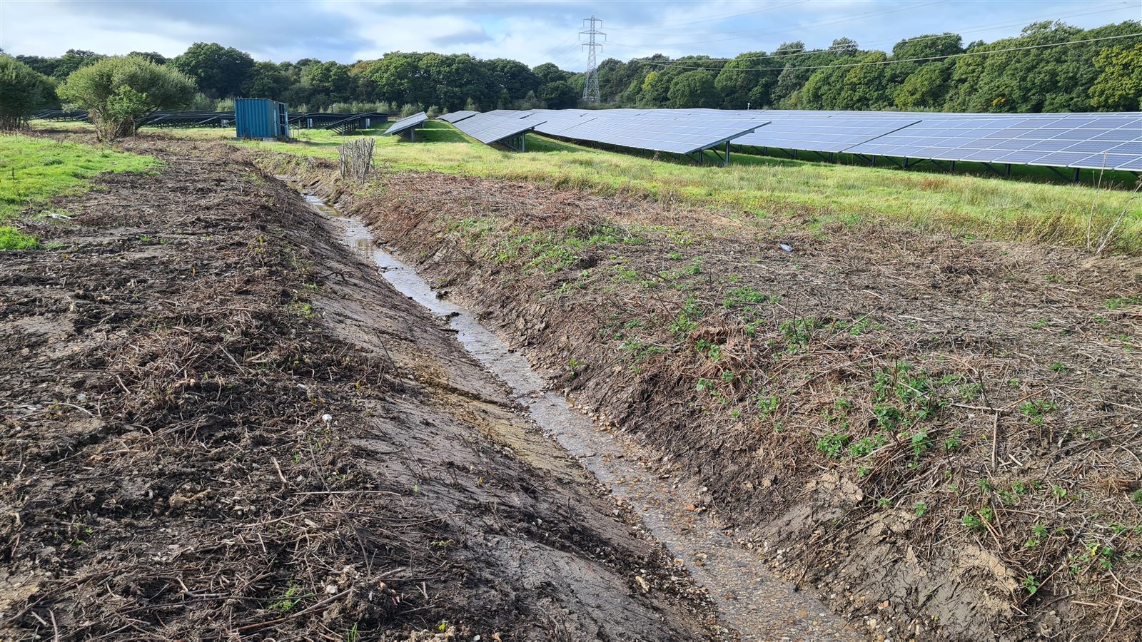 A clear access route alongside a solar farm ditch