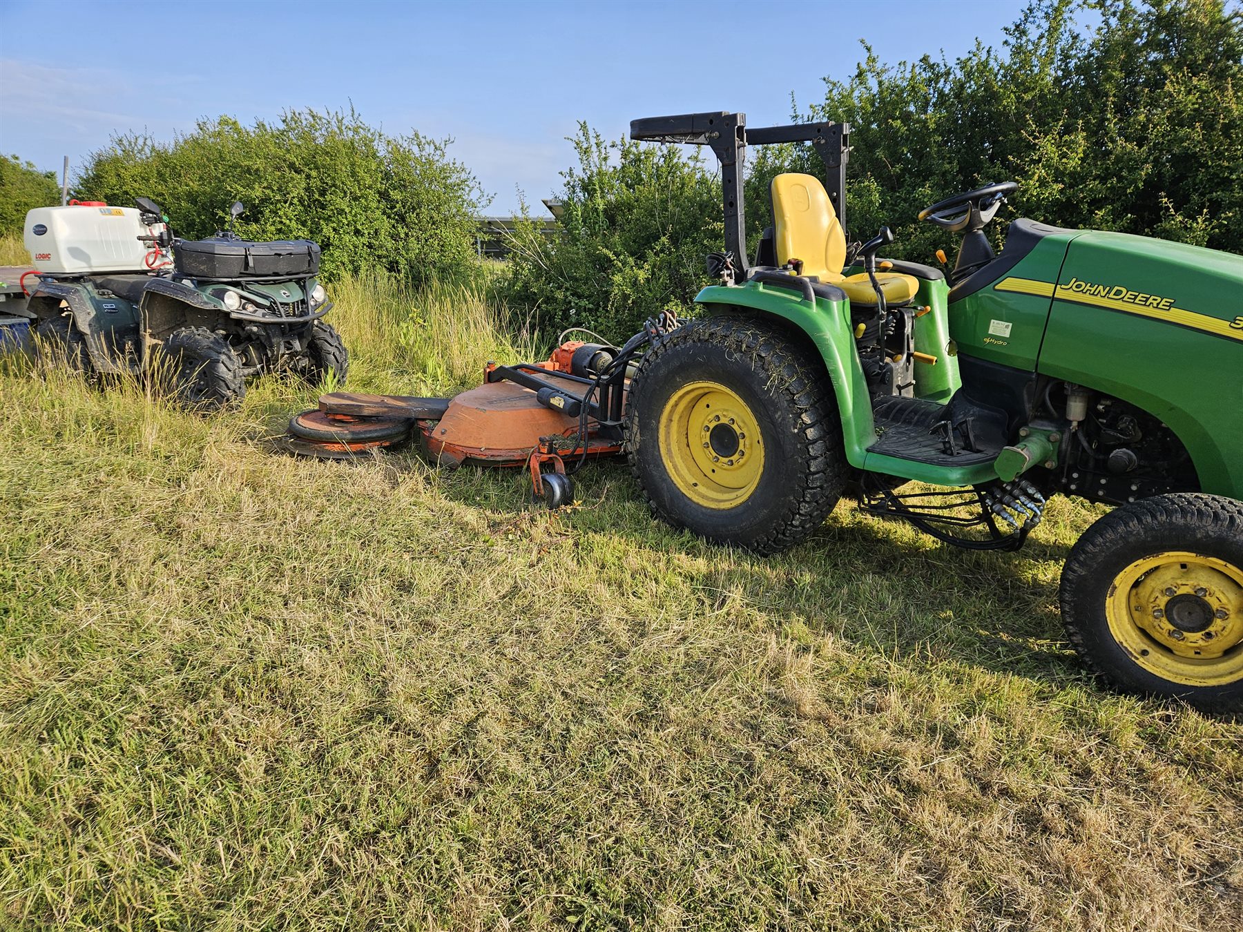 Tractor flail mower cutting vegetation on a solar farm