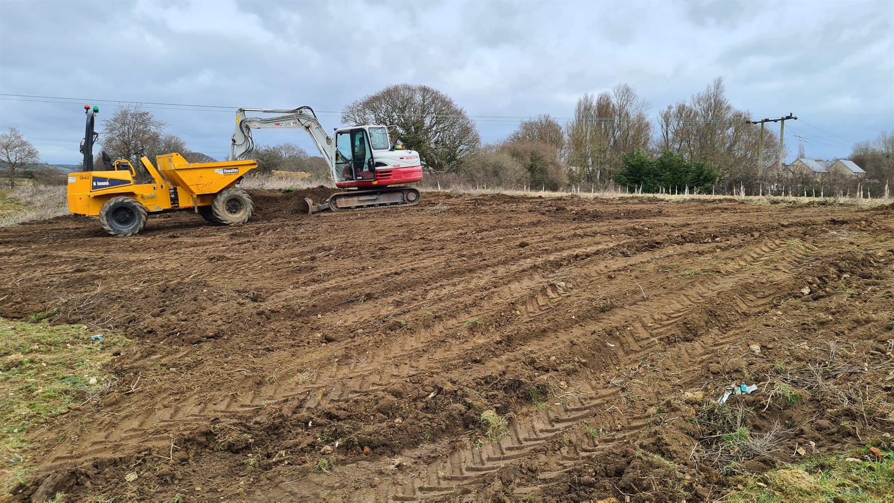 Machinery cultivating soil for a new wildflower meadow